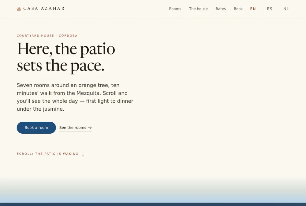 The Casa Azahar home page: the headline “The courtyard runs this house” set in a roman face over pale limewash, the indigo “Book a room” button and, below it, the edge of the sky where the courtyard begins.